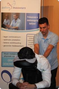 Eén van de stoelmasseurs geeft een gratis behandeling stoelmassage. stoelmassages in hardenberg tijdens business vakdagen