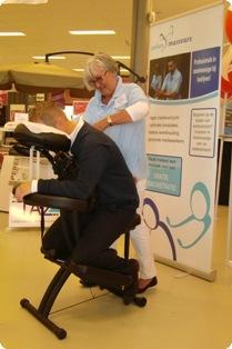 Corry geeft een behandeling stoelmassage aan een bezoeker van de Staples Office Centre Ondernemersdag in Assen, Drenthe.